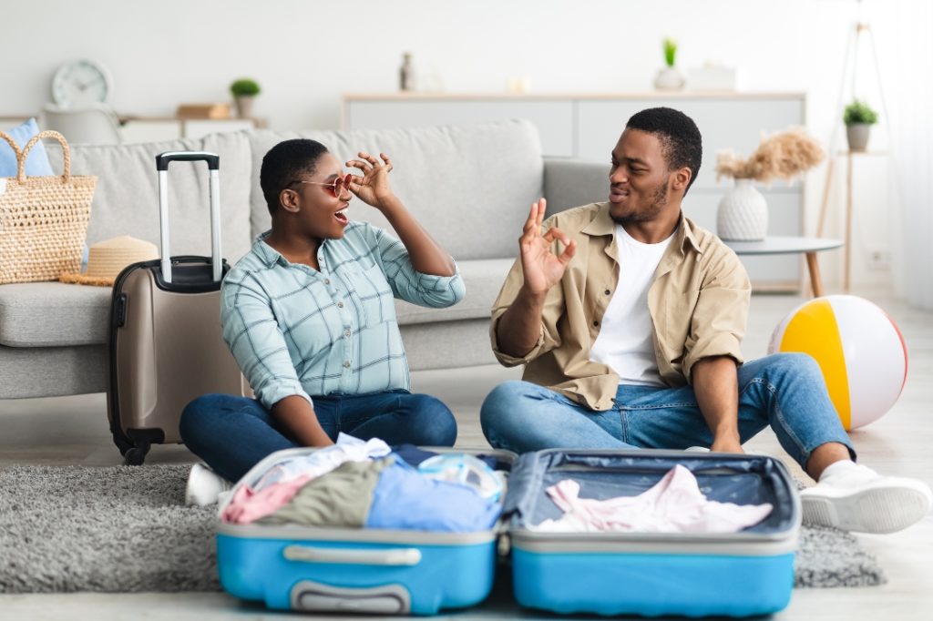 Casal feliz na sala de estar fazendo sua mala para férias de verão.