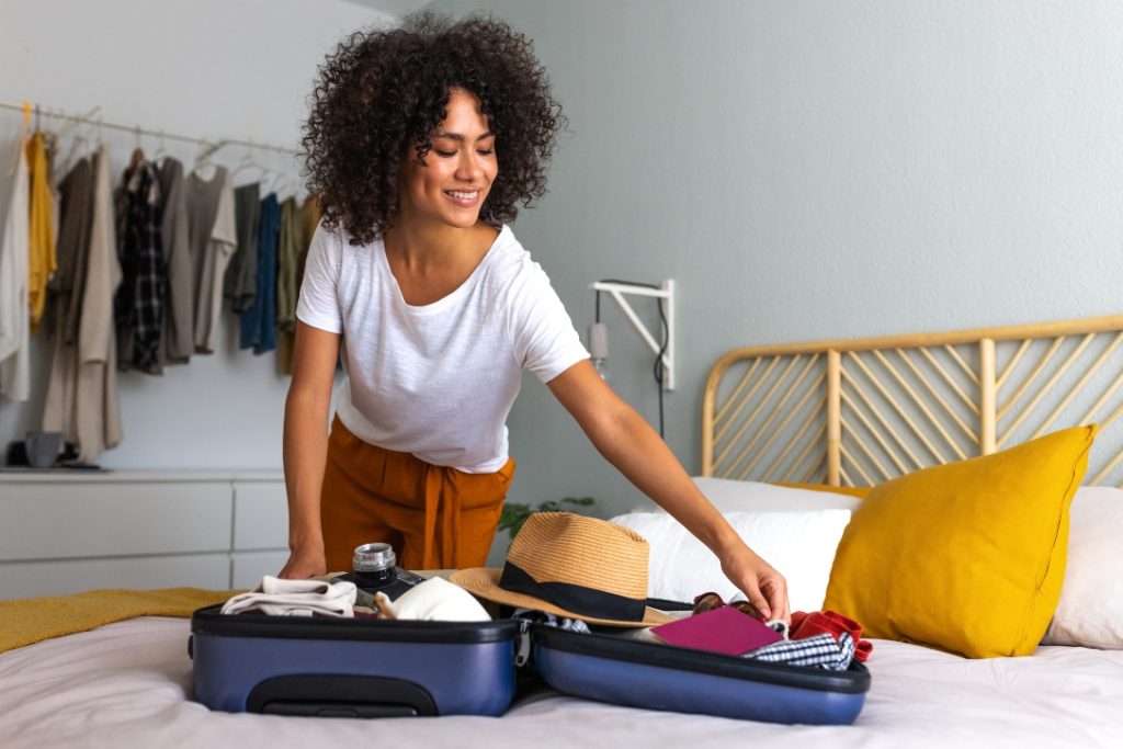 Mulher arrumando mala para viajar.